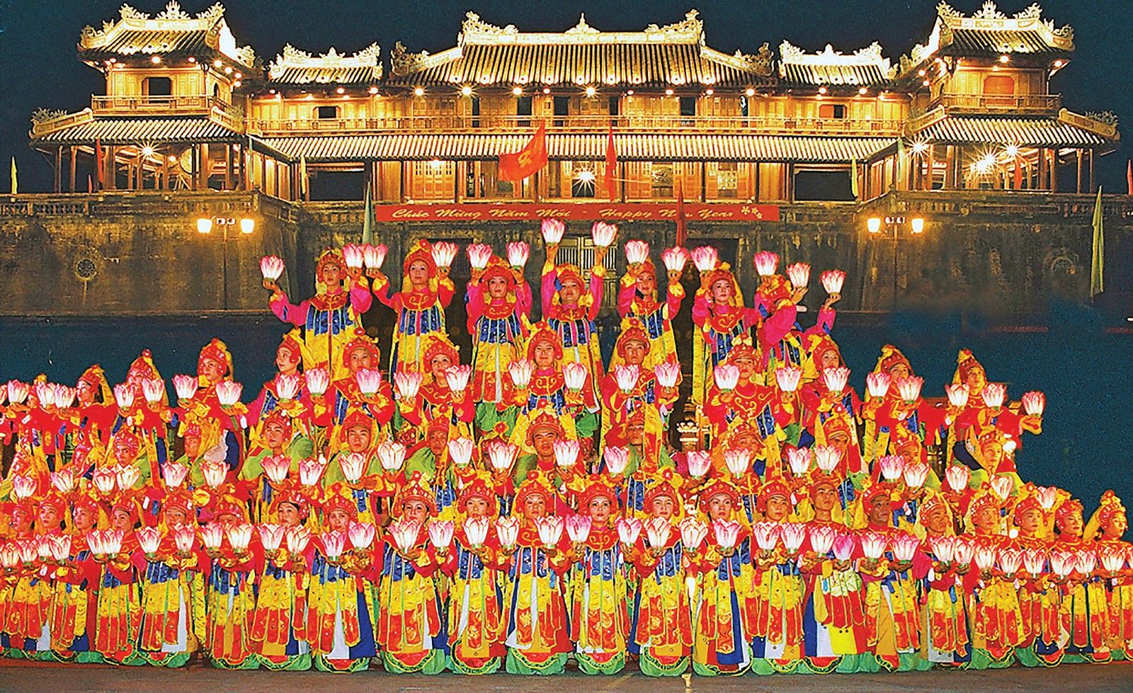 Biểu diễn Nhã nhạc Cung đình Huế tại Đại Nội về đêm trong khuôn khổ lễ hội văn hóa Việt Nam, các nghệ sĩ mặc trang phục truyền thống và cầm hoa sen rực rỡ