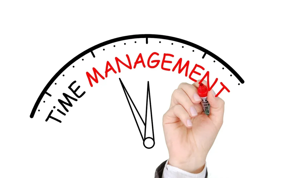 Đồng hồ hiển thị từ "Time Management" với bàn tay đang viết, tượng trưng cho kỹ năng quản lý thời gian hiệu quả.